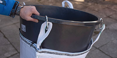 Schuttrutsche montieren Schritt 1 – Karabinerhaken des Einfülltrichters in Schlaufen einhängen